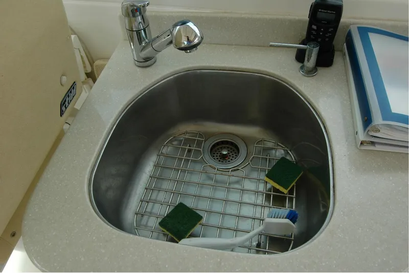 Slide: The Image of 2014 Back Cove 34 yacht sink with sponges and brush on countertop. - 53