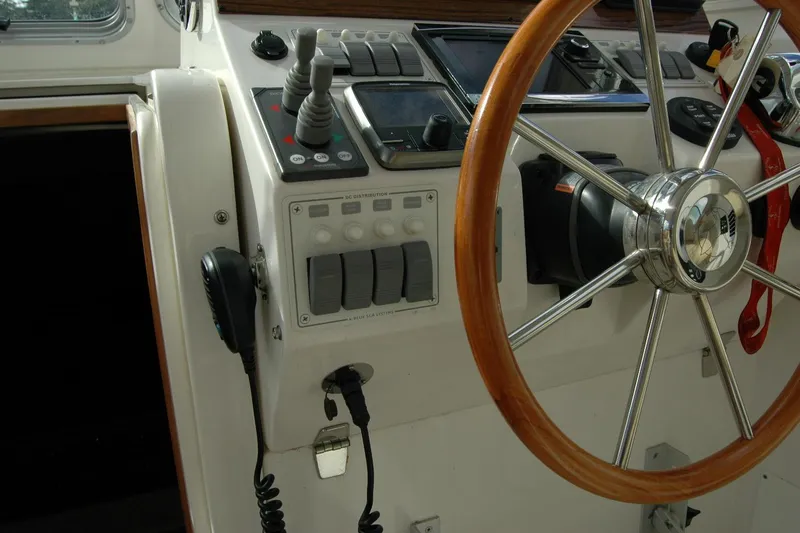 Slide: The Image of Steering wheel and controls of a 2014 Back Cove 34 boat cockpit. - 59
