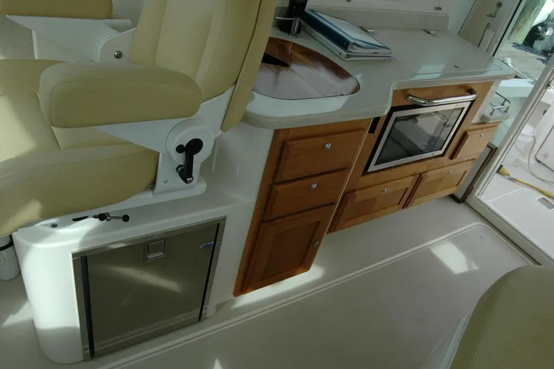 Slide: The Image of 2014 Back Cove 34 interior with beige seating, kitchenette, and wooden cabinetry. - 65
