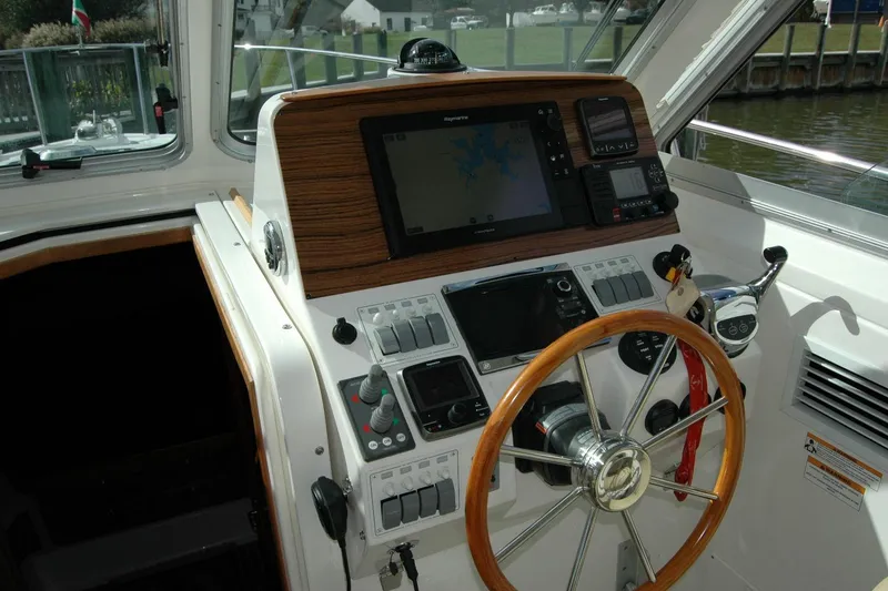 Slide: The Image of 2014 Back Cove 34 helm with wooden steering wheel and navigation equipment. - 67