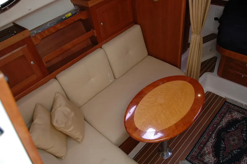 Slide: The Image of Interior of 2014 Back Cove 34 yacht with beige seating and oval wooden table. - 76