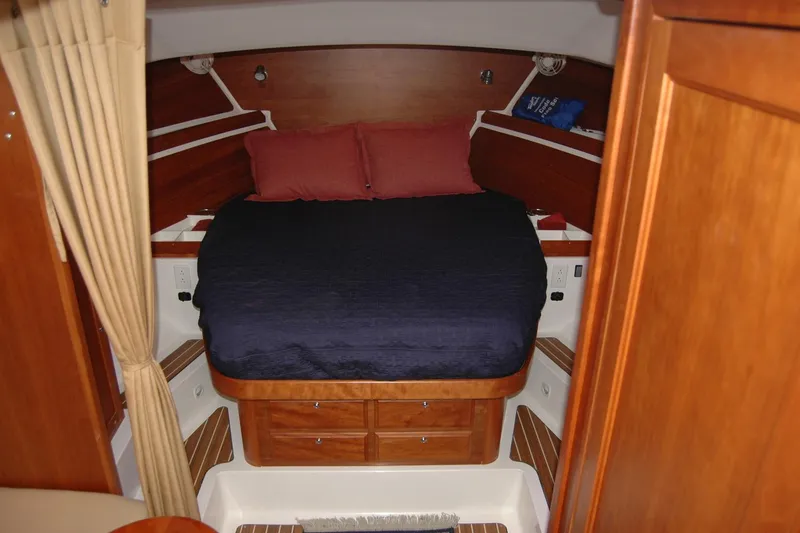 Slide: The Image of 2014 Back Cove 34 cabin interior with bed, wood paneling, and storage drawers. - 78