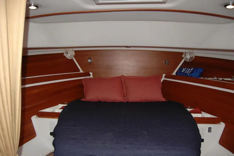 Slide: The Image of 2014 Back Cove 34 cabin interior with cozy bed and wooden accents. - 82