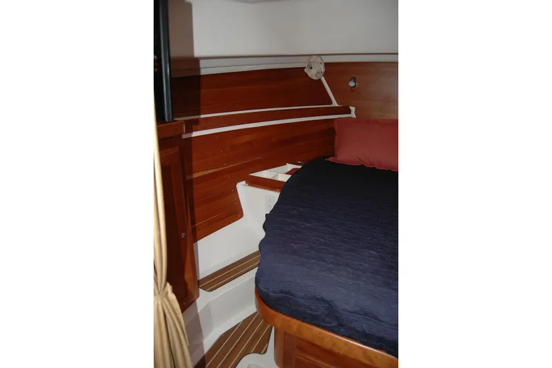 Slide: The Image of Interior cabin of 2014 Back Cove 34 boat with wooden paneling and cozy bedding. - 85