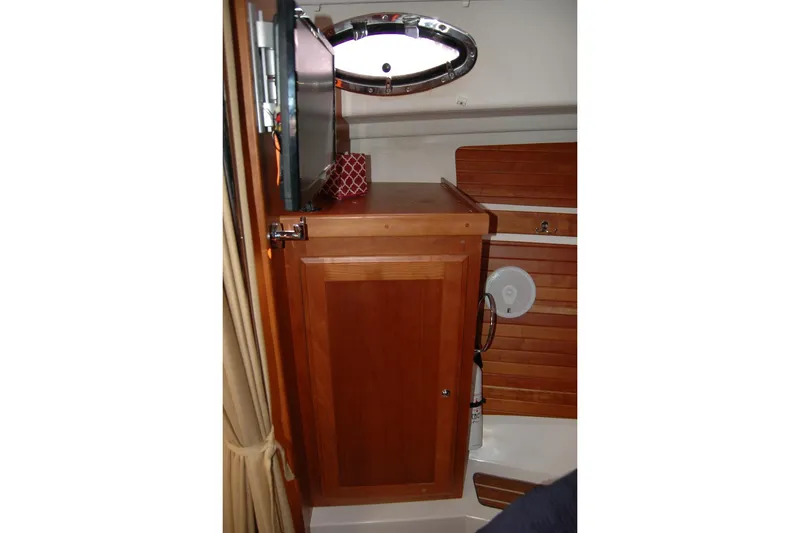 Slide: The Image of 2014 Back Cove 34 interior with wooden cabinetry and porthole window. - 86