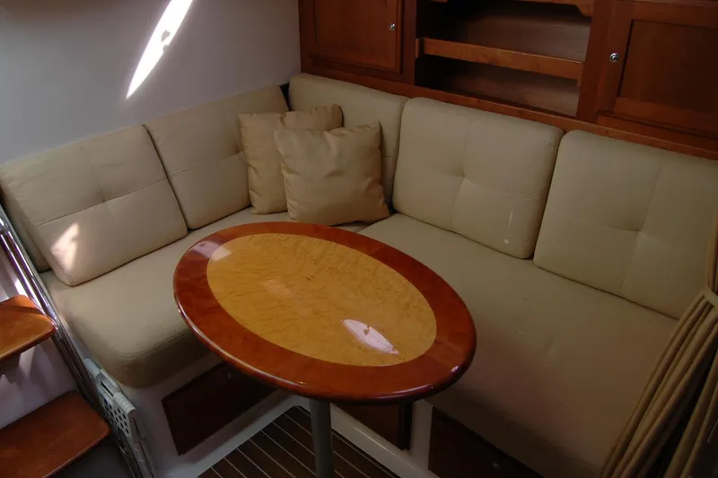 Slide: The Image of Interior of 2014 Back Cove 34 with beige seating and wooden table. - 93