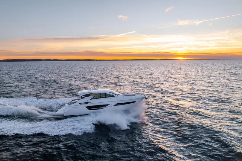 Slide: The Image of 2026 Cruisers Yachts 46 Cantius cruising at sunset on open water. - 53