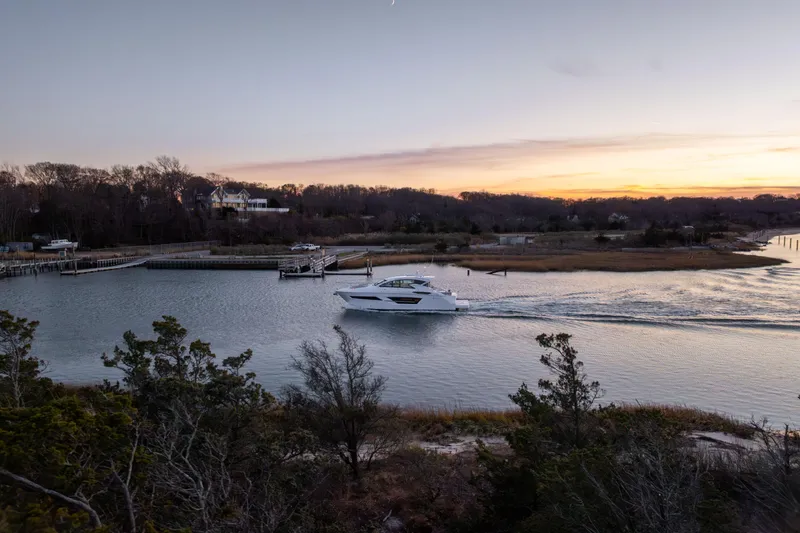Slide: The Image of 2026 Cruisers Yachts 46 Cantius sailing at sunset in a serene coastal setting. - 58