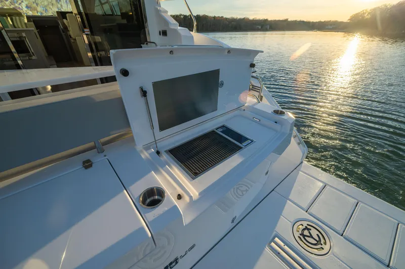 Slide: The Image of 2026 Cruisers Yachts 46 Cantius with outdoor grill, docked at sunset. - 11