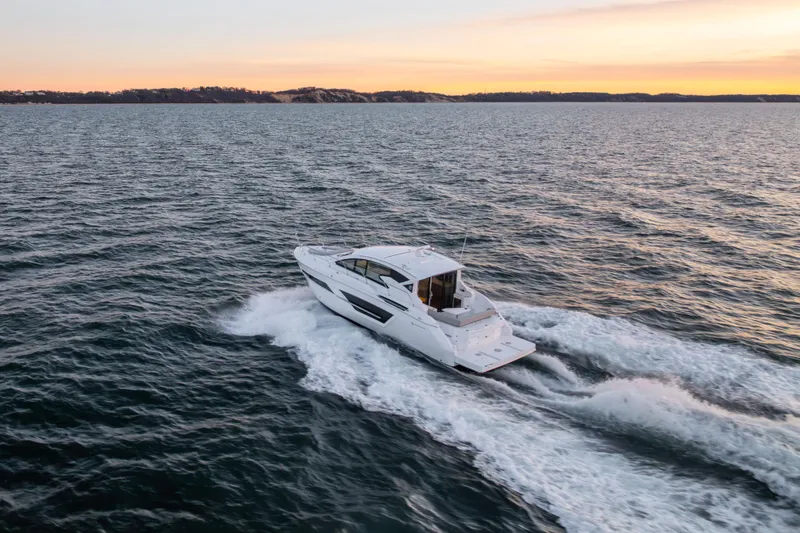 Slide: The Image of 2026 Cruisers Yachts 46 Cantius cruising at sunset on open water. - 54