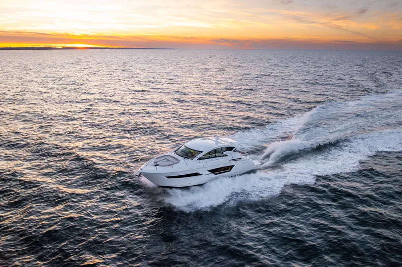 Slide: The Image of 2026 Cruisers Yachts 46 Cantius cruising at sunset on open water. - 55