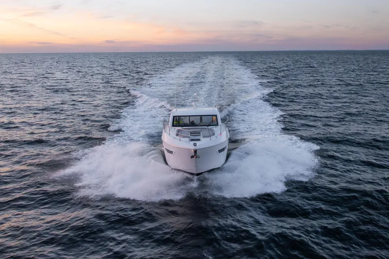 Slide: The Image of 2026 Cruisers Yachts 46 Cantius cruising at sunset on open water. - 56