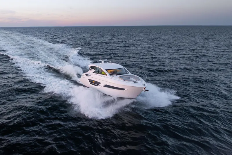 Slide: The Image of 2026 Cruisers Yachts 46 Cantius cruising on open water at sunset. - 57
