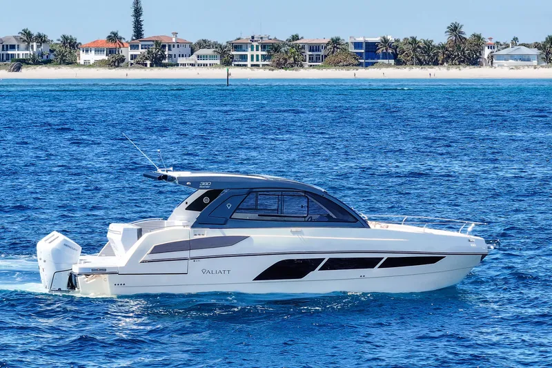 Slide: The Image of 2025 VALIATT YACHTS 380 Bowrider cruising on blue ocean near sandy beach. - 12