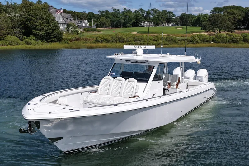 Slide: The Image of 2026 Everglades 455 Center Console boat cruising on a scenic lake. - 1