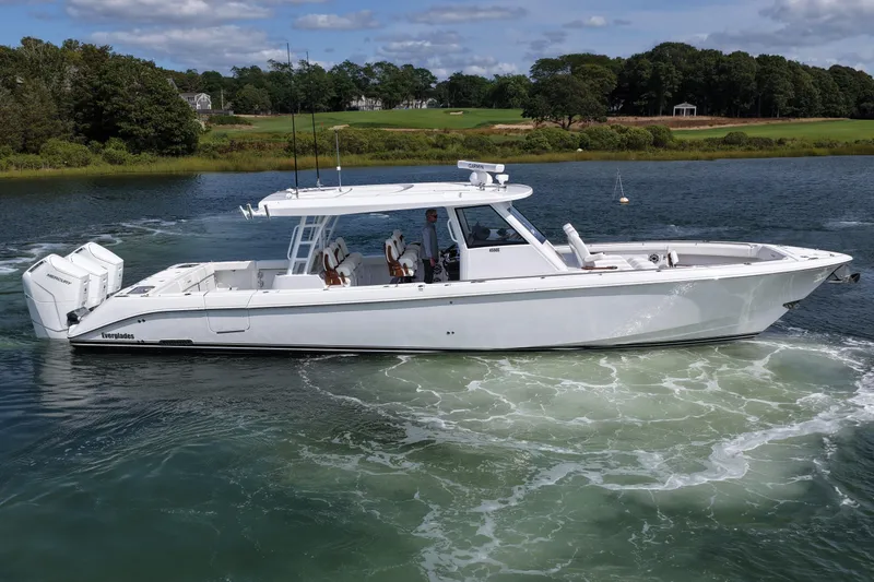 Slide: The Image of 2026 Everglades 455 Center Console boat cruising on a scenic waterway. - 5