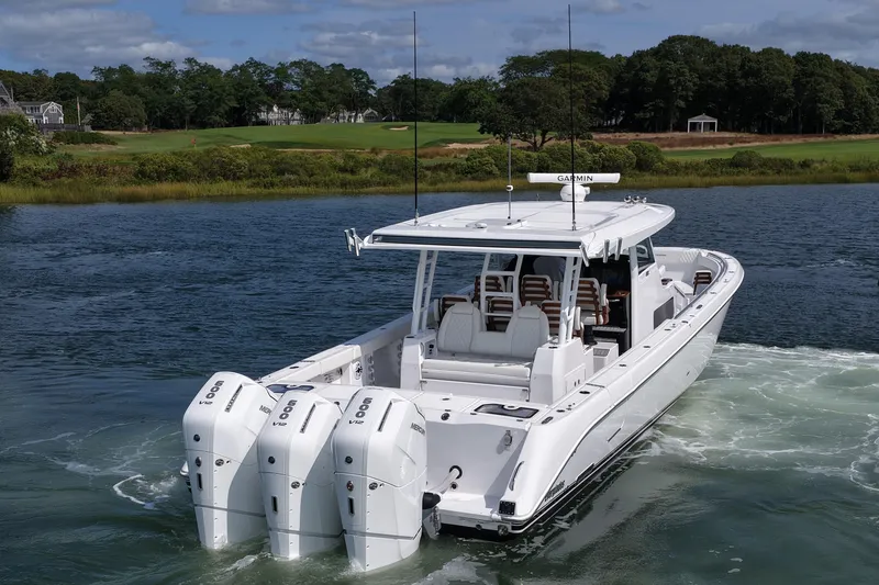 Slide: The Image of 2026 Everglades 455 Center Console boat with triple engines on a scenic waterway. - 7