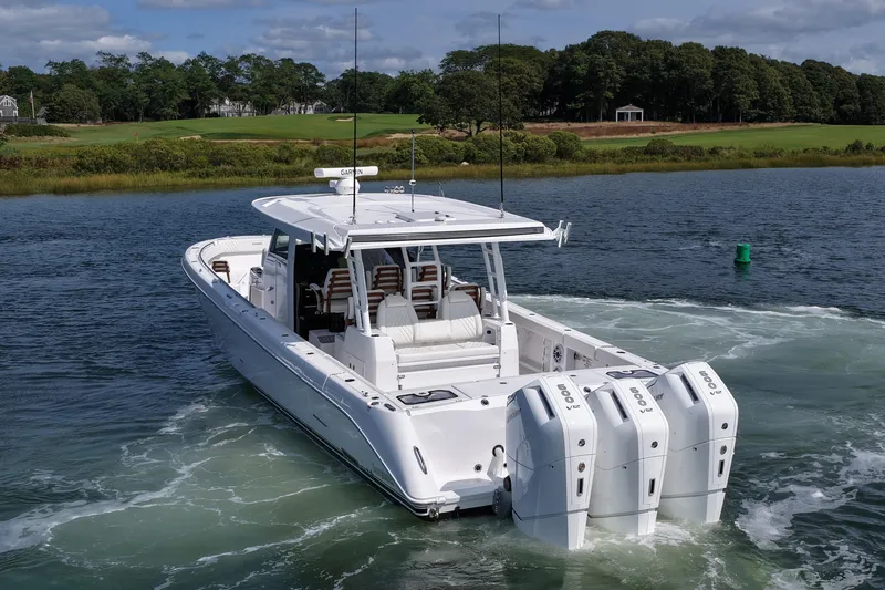 Slide: The Image of 2026 Everglades 455 Center Console boat cruising on a scenic waterway. - 9