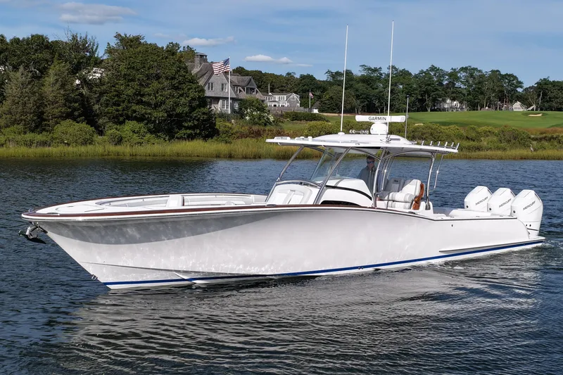 Slide: The Image of 2026 Mag Bay 38 boat cruising on a serene lake with lush greenery. - 10