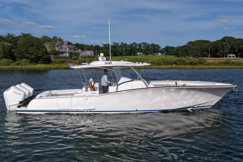 Slide: The Image of 2026 Mag Bay 38 boat cruising on a serene lake with scenic background. - 3