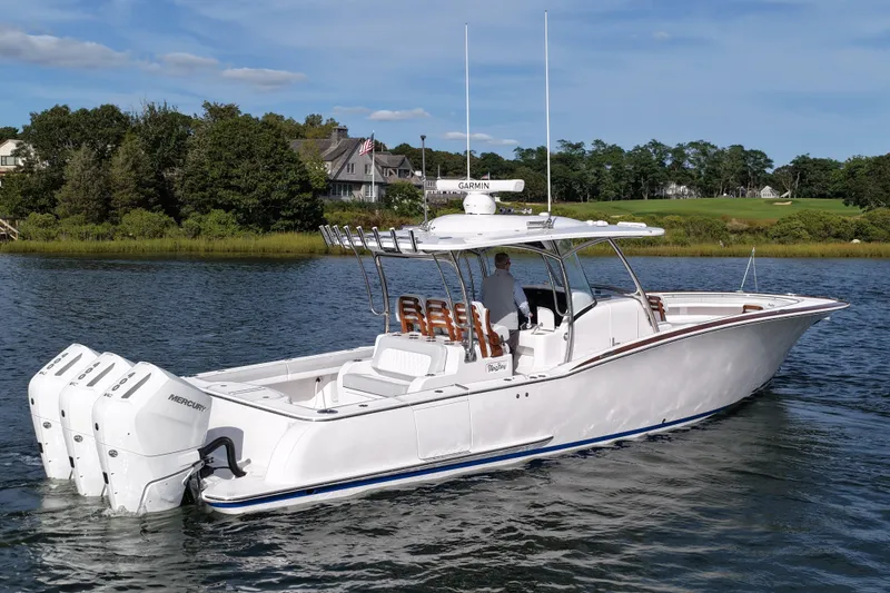 Slide: The Image of 2026 Mag Bay 38 boat on water, featuring triple Mercury engines and sleek design. - 4