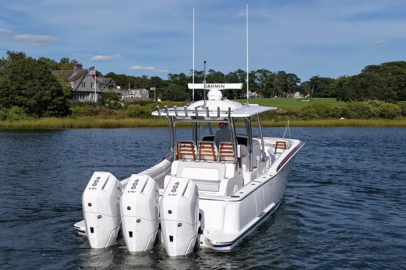 Slide: The Image of 2026 Mag Bay 38 boat with triple outboard engines on a scenic waterway. - 5