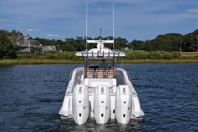 Slide: The Image of 2026 Mag Bay 38 boat with four powerful engines on a serene lake. - 6