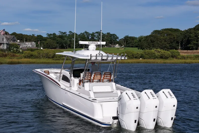 Slide: The Image of 2026 Mag Bay 38 boat with triple Mercury engines on a scenic waterway. - 7