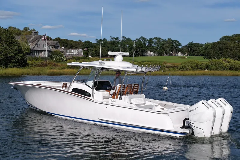 Slide: The Image of 2026 Mag Bay 38 boat cruising on a serene lake with scenic background. - 8