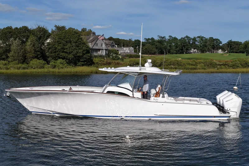 Slide: The Image of 2026 Mag Bay 38 boat cruising on a serene lake with scenic background. - 9