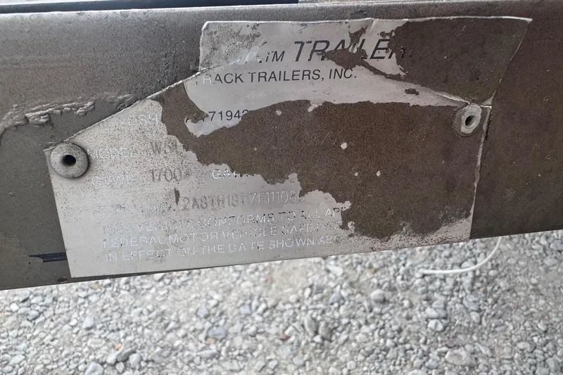 Slide: The Image of Weathered trailer identification plate with partially visible text, mounted on a metal frame. - 11