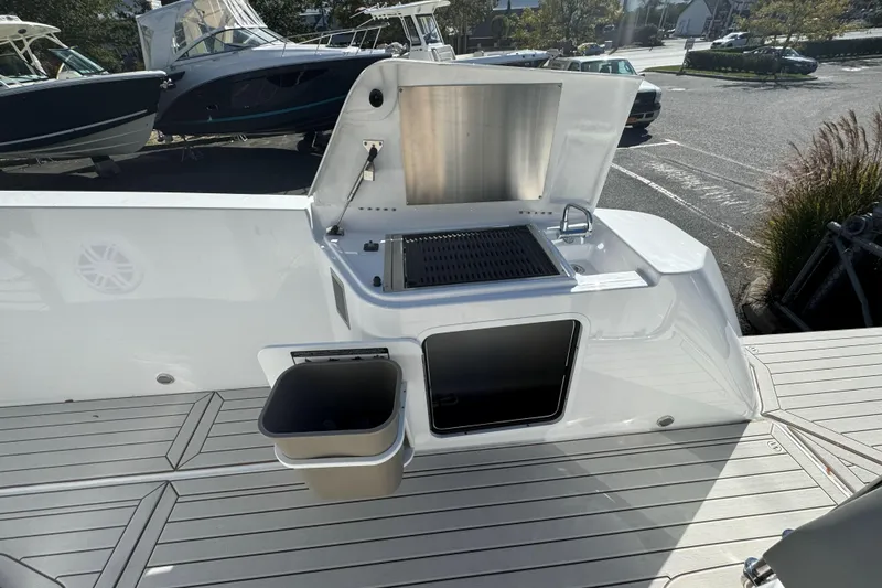 Slide: The Image of 2026 Cruisers Yachts 38 VTR helm with Simrad navigation, overlooking serene ocean view. - 12