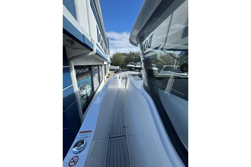 Slide: The Image of 2026 Cruisers Yachts 38 VTR, sleek deck view, docked beside a building. - 24