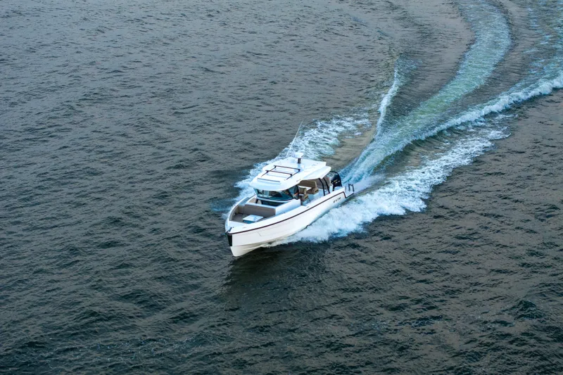 Slide: The Image of 2026 Cruisers Yachts 38 VTR with Mercury engine, viewed from deck under clear blue sky. - 5