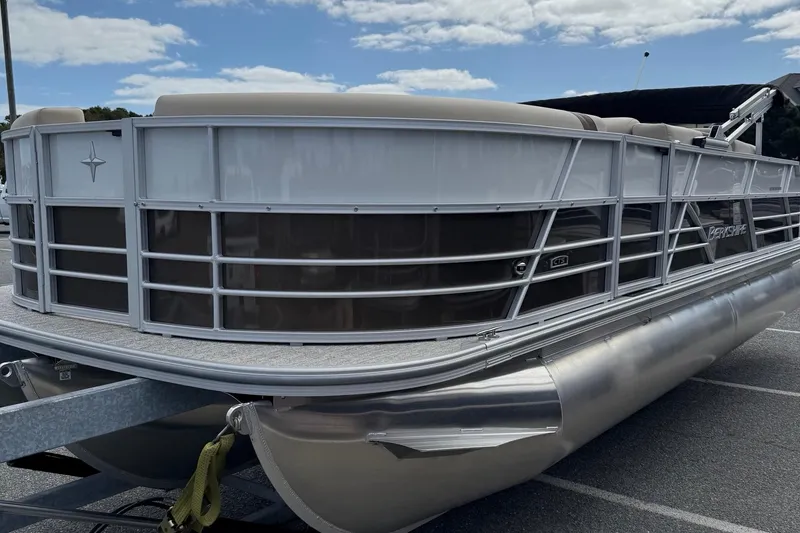 Slide: The Image of 2026 Berkshire 24RFC2 CTS 2.75 pontoon boat with sleek design in a parking lot. - 4