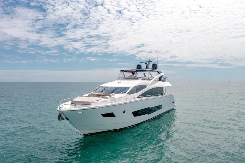 Slide: The Image of Luxurious 2021 Sunseeker 86 Yacht cruising on calm ocean waters under a partly cloudy sky. - 5