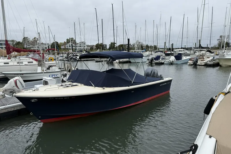 Slide: The Image of 2015 Rossiter 23 boat docked at marina, featuring sleek design and canopy. - 1