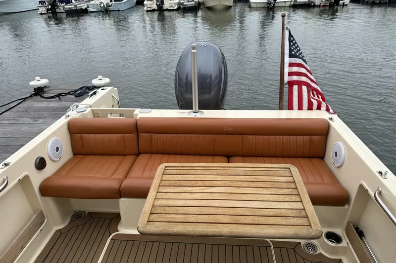 Slide: The Image of 2015 Rossiter 23 boat with Yamaha outboard motor, docked with blue cover. - 13