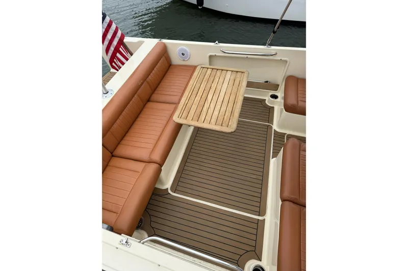 Slide: The Image of 2015 Rossiter 23 boat interior with brown leather seating and wood flooring. - 25