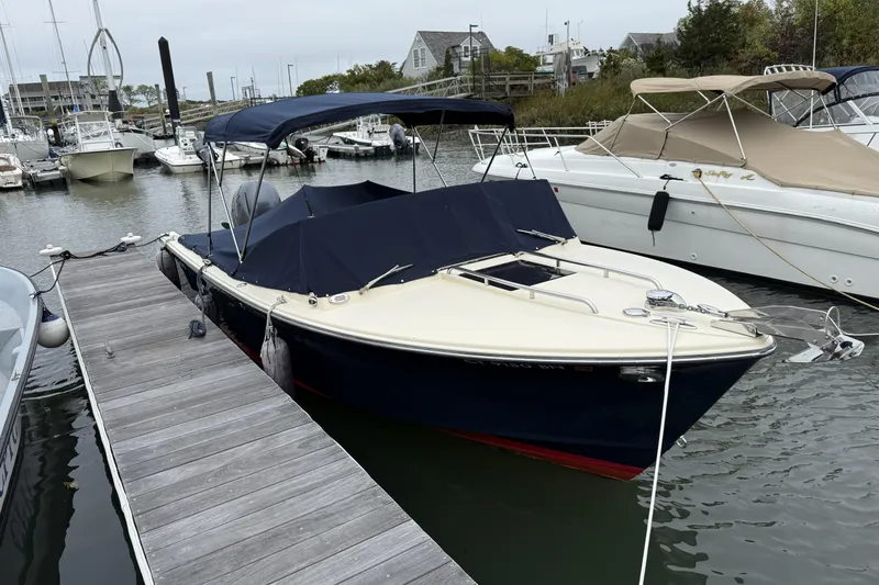 Slide: The Image of 2015 Rossiter 23 boat docked on a sunny day with lush greenery background. - 3