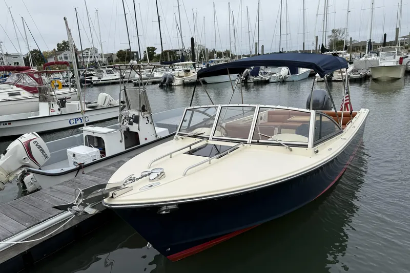 Slide: The Image of 2015 Rossiter 23 boat docked in a marina with other vessels. - 33