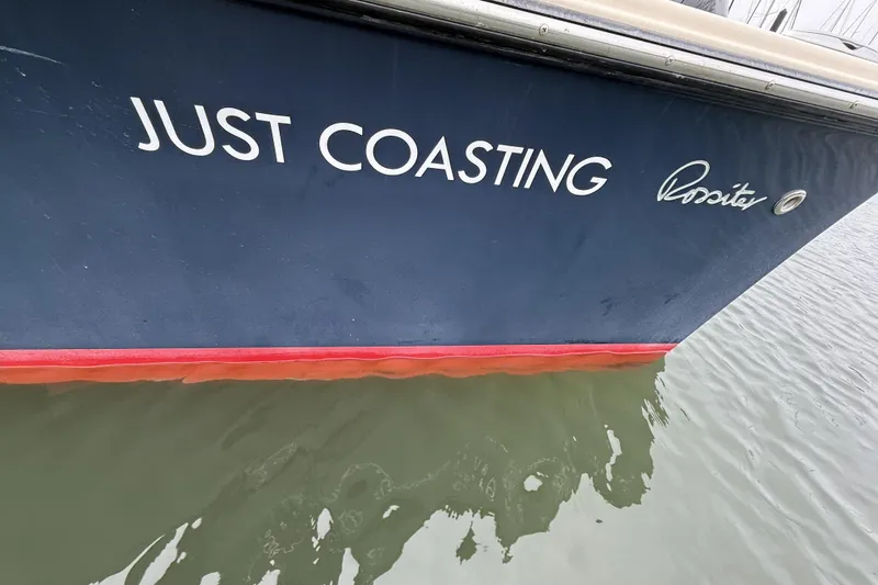 Slide: The Image of Blue Rossiter 23 boat named "Just Coasting" on water, 2015 model. - 35