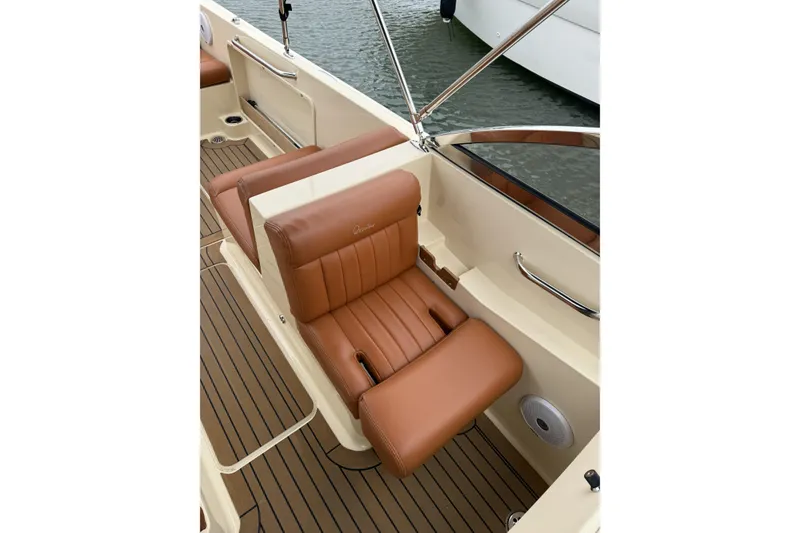 Slide: The Image of 2015 Rossiter 23 boat with canopy docked near lush greenery and modern house. - 6