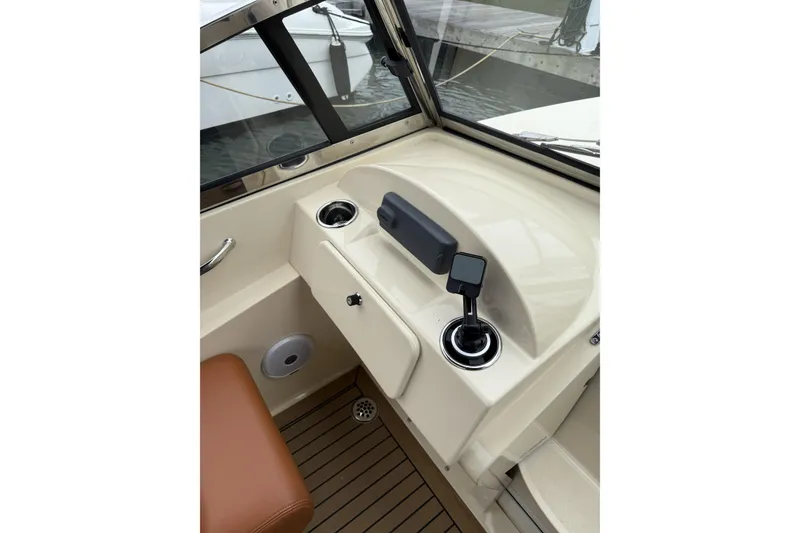 Slide: The Image of 2015 Rossiter 23 boat docked, covered with a blue canopy, featuring an outboard motor. - 7