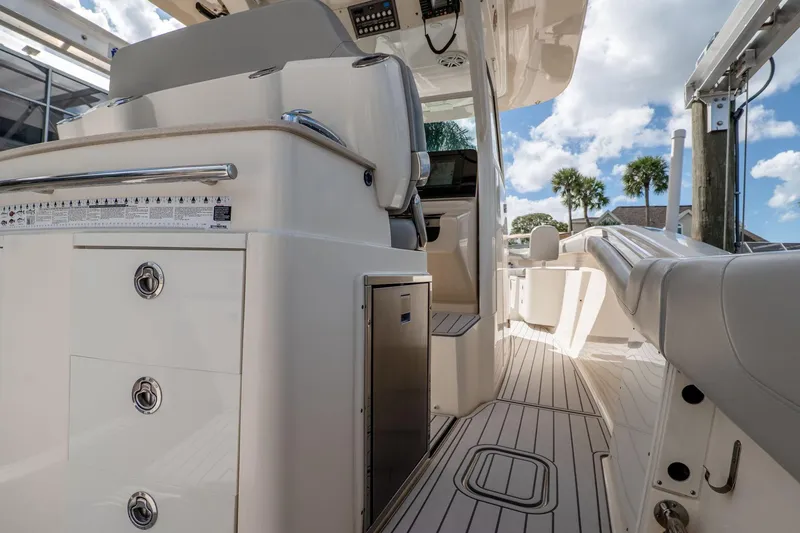 Slide: The Image of 2019 Scout 320 LXF boat interior with seating, storage, and sleek design under a blue sky. - 15