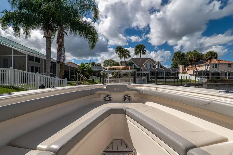 Slide: The Image of 2019 Scout 320 LXF boat interior with palm trees and waterfront homes in the background. - 25