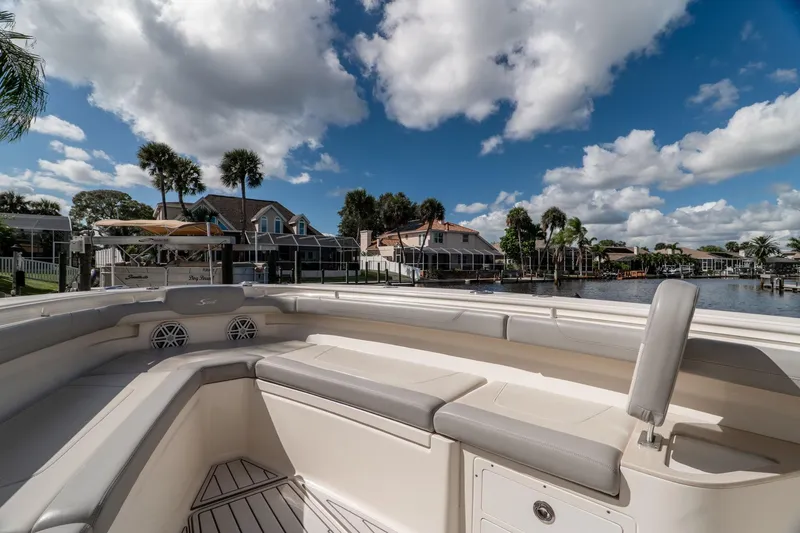Slide: The Image of 2019 Scout 320 LXF boat interior with waterfront view, under a partly cloudy sky. - 28