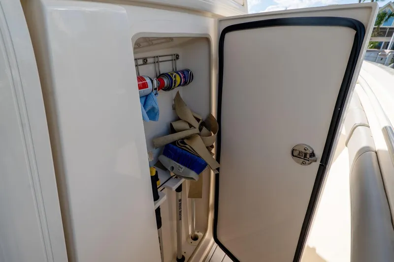 Slide: The Image of Storage compartment on 2019 Scout 320 LXF boat with cleaning supplies and tools. - 30