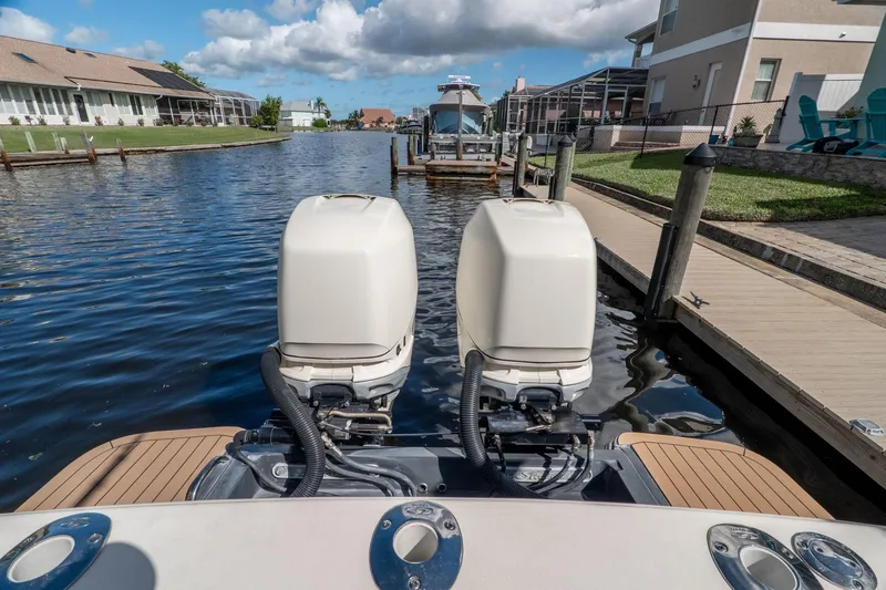 Slide: The Image of 2019 Scout 320 LXF boat with dual outboard engines docked in a canal. - 9
