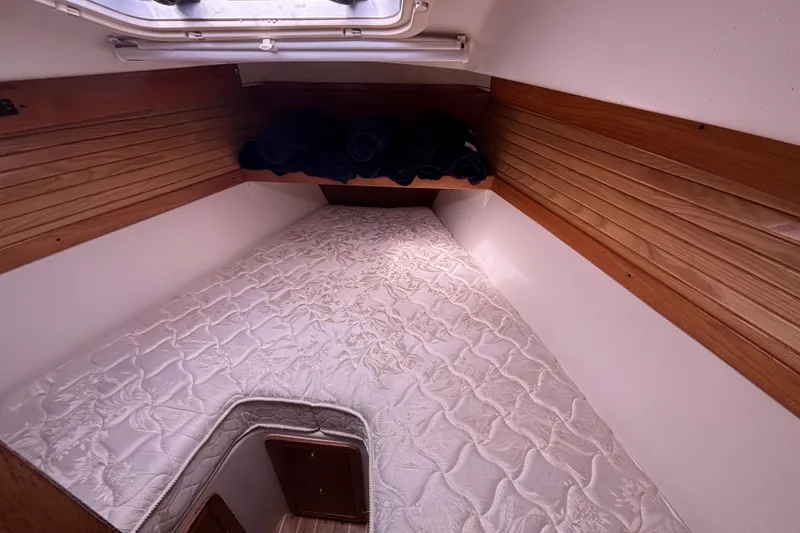 Slide: The Image of Cozy cabin interior of 2006 Catalina 320 sailboat with wooden accents and comfortable bedding. - 20